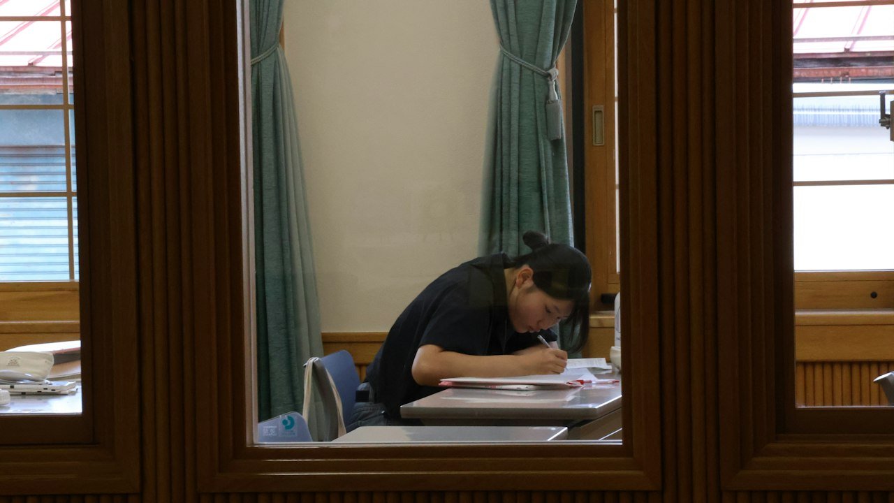 窓辺の机で勉強する人(イメージ)