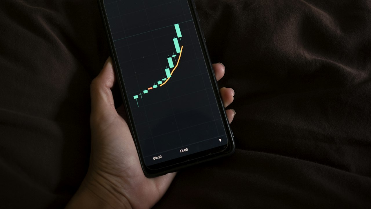 スマートフォンで値動きのチャートを見る様子(イメージ)