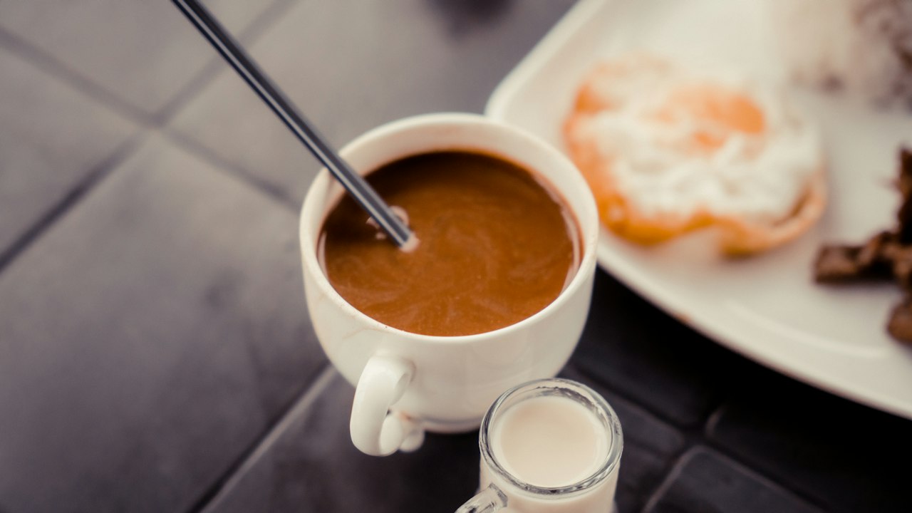 ミルク入りのコーヒーと朝食(イメージ)