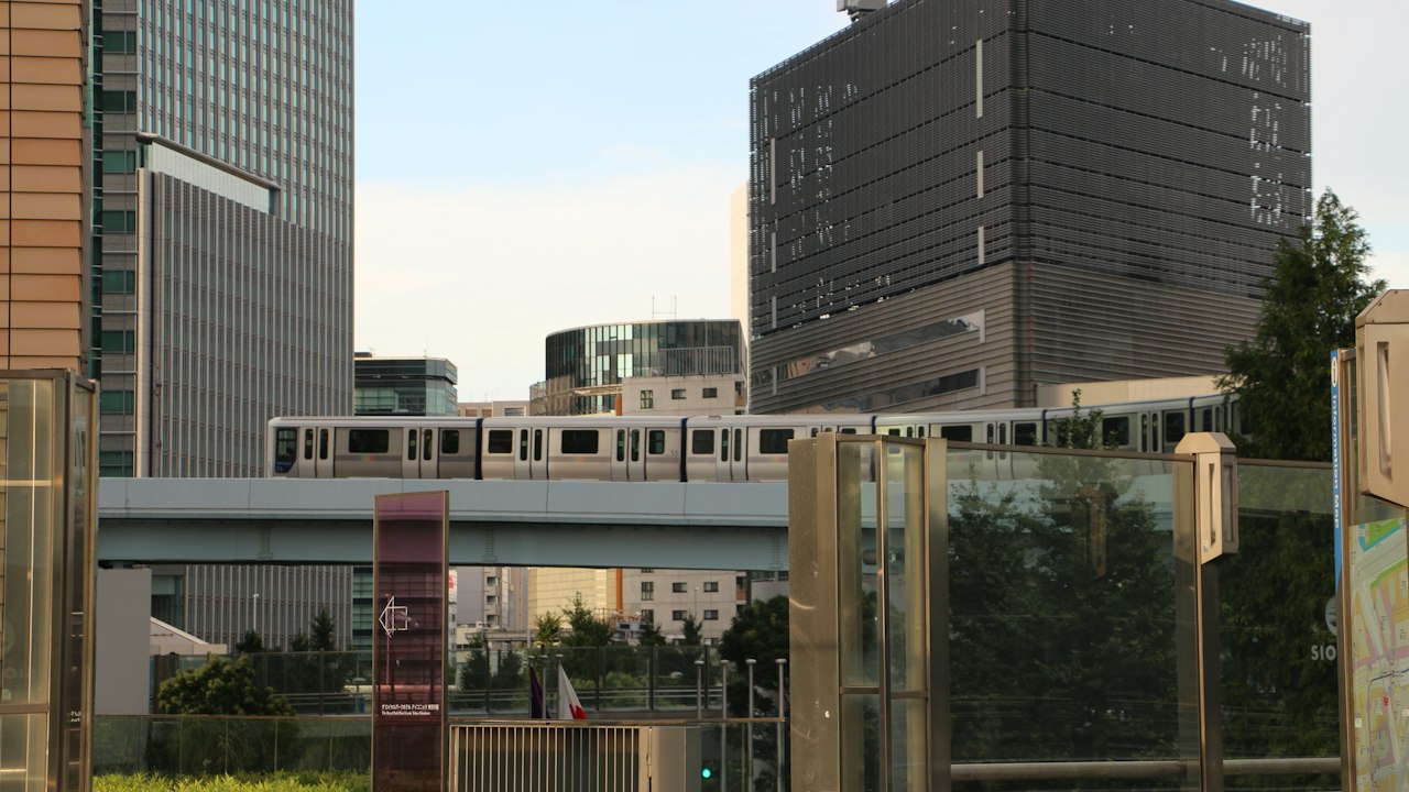 ビルの間の高架を走る電車(イメージ)